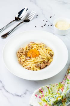 pasta in cream sauce with egg and black pepper on top