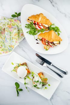 canapes on black bread with cheese, red fish, herbs and cucumber