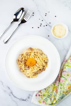 pasta in cream sauce with egg and black pepper on top