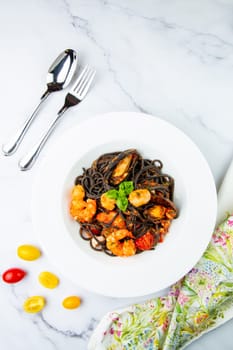 black noodles with mussels, shrimp, tomatoes and herbs