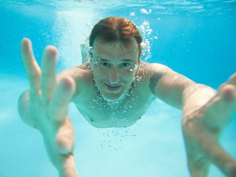 Man swimming under water in pool