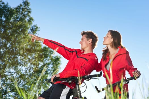 Summer - young man woman couple ride mountain bike in nature