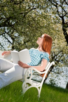 Summer - young woman relaxing bench park