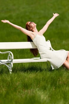 Summer - young woman relaxing bench park