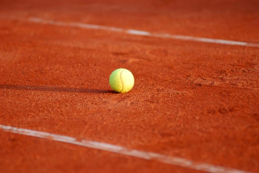 Tennis ball on a red court