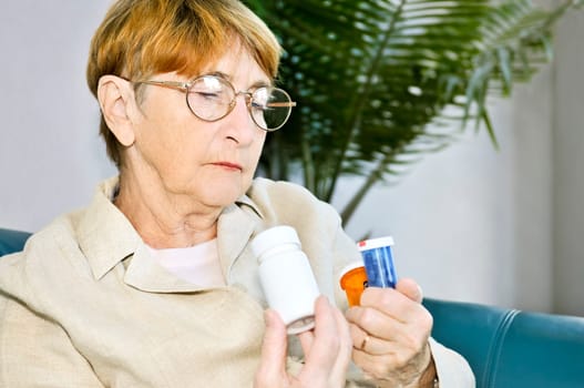 Elderly woman reading pill bottles