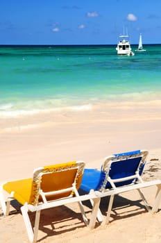 Chairs on sandy tropical beach