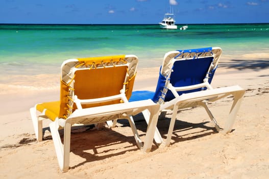 Chairs on sandy tropical beach