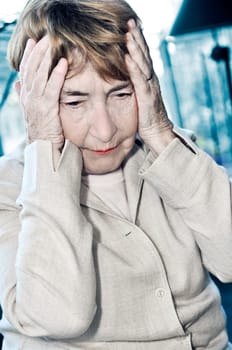 Elderly woman holding head