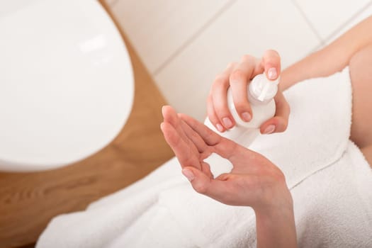 Body care series - applying lotion in the bathroom
