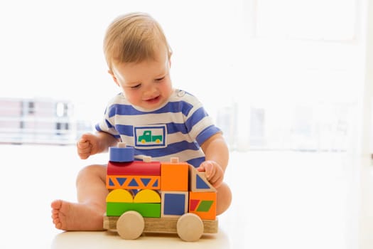 Baby indoors playing with truck