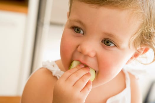 Young girl eating apple indoors