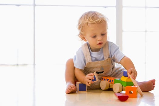 Baby indoors playing with toy truck