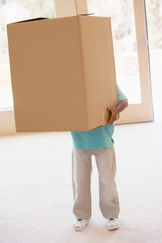 Young boy holding box in new home