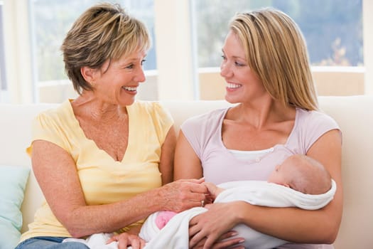 Grandmother and mother in living room with baby smiling