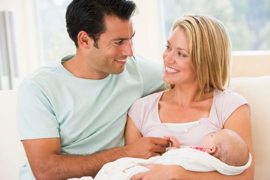 Couple in living room with baby smiling