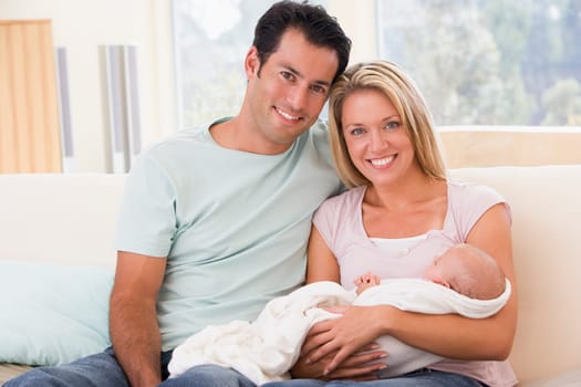 Couple in living room with baby smiling