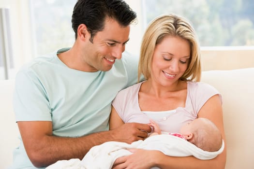 Couple in living room with baby smiling