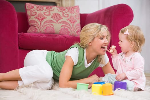 Mother in living room with baby eating banana and smiling