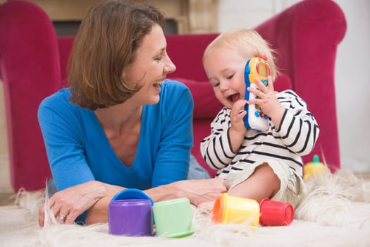 Mother in living room playing with baby smiling
