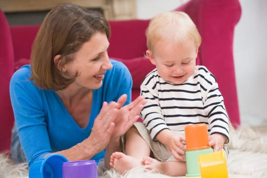 Mother in living room playing with baby smiling