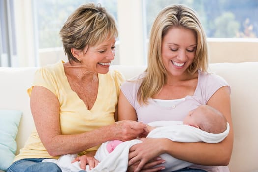 Grandmother and mother in living room with baby smiling