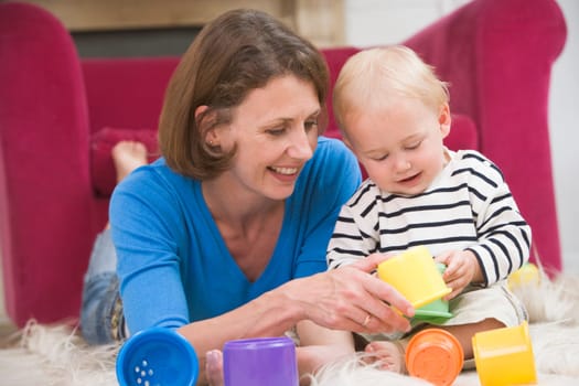 Mother in living room playing with baby smiling