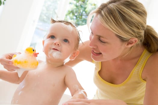 Mother giving baby bubble bath smiling