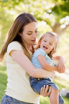 Mother holding daughter outdoors smiling
