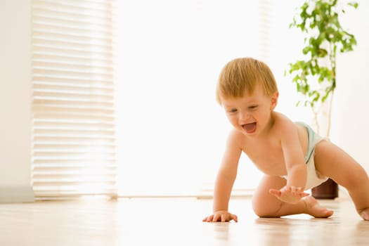 Baby crawling indoors smiling