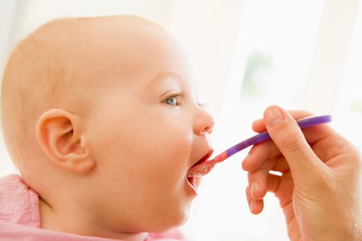 Mother feeding baby food to baby