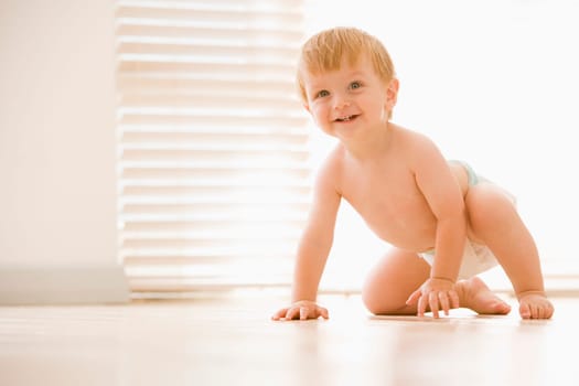 Baby crawling indoors smiling