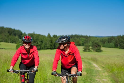 Summer - young man woman couple ride mountain bike in nature