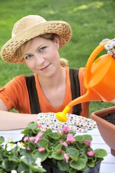 Young woman watering flowers