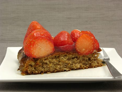 A piece of strawberry cake on white plate