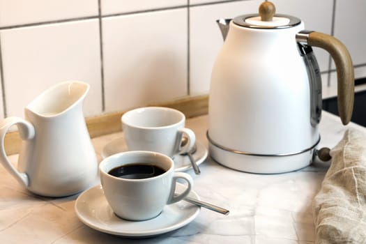 Breakfast on the kitchen table with coffee cup and kettle. High quality photo