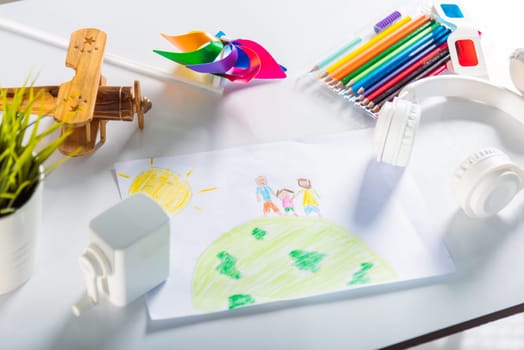 Child colorful drawing family standing hold hands on planet earth on white paper, Kid preschooler draw picture with pencil on table, Earth day concept