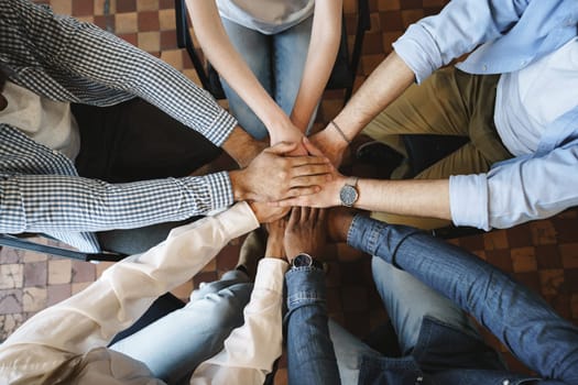 Top view of diverse people hands holding together in circle, hands stack, close up