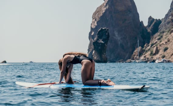 Close up shot of beautiful young caucasian woman with black hair and freckles looking at camera and smiling. Cute woman portrait in a pink bikini posing on a volcanic rock high above the sea