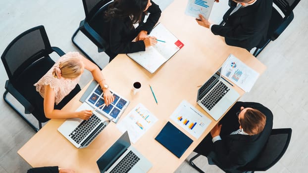 Business people group meeting shot from top view in office . Profession businesswomen, businessmen and office workers working in team conference with project planning document on meeting table . Jivy