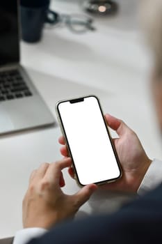 Close up man using smartphone at office desk. Empty screen for your advertising text message.