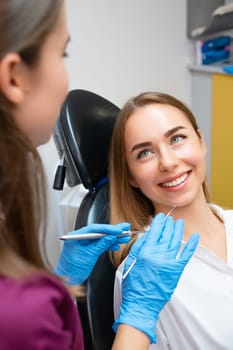 Portrait of young caucasian woman with perfect smile in dental clinic, vertical photo