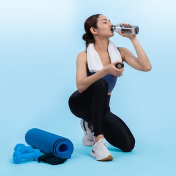 Athletic and sporty asian woman resting and drink water after intensive cardio workout training. Healthy exercising and fit body care lifestyle pursuit in studio shot isolated background. Vigorous