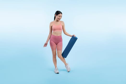 Young attractive asian woman portrait in sportswear with exercising mat. Healthy exercise and workout routine lifestyle concept. Studio shot isolated background. Vigorous