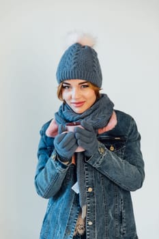 woman in warm winter clothes with a mug of mulled wine coffee tea