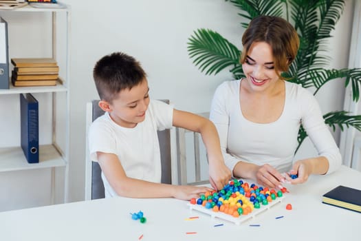 educational games for children a child psychologist is engaged in a color mosaic with a boy in the office