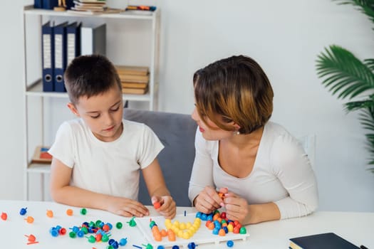 educational games for children a child psychologist is engaged in a color mosaic with a boy in the office