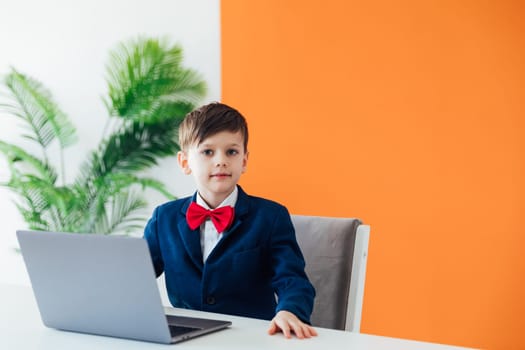 at school in room in the classroom education online boy sitting at a laptop at a table