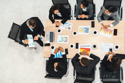 Business people group meeting shot from top view in office . Profession businesswomen, businessmen and office workers working in team conference with project planning document on meeting table . Jivy