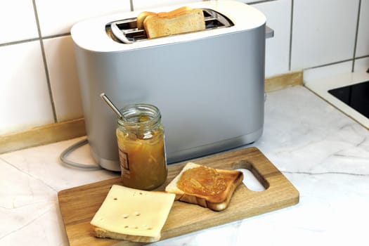 Breakfast served on the kitchen table with fresh toast bread and jam. High quality photo